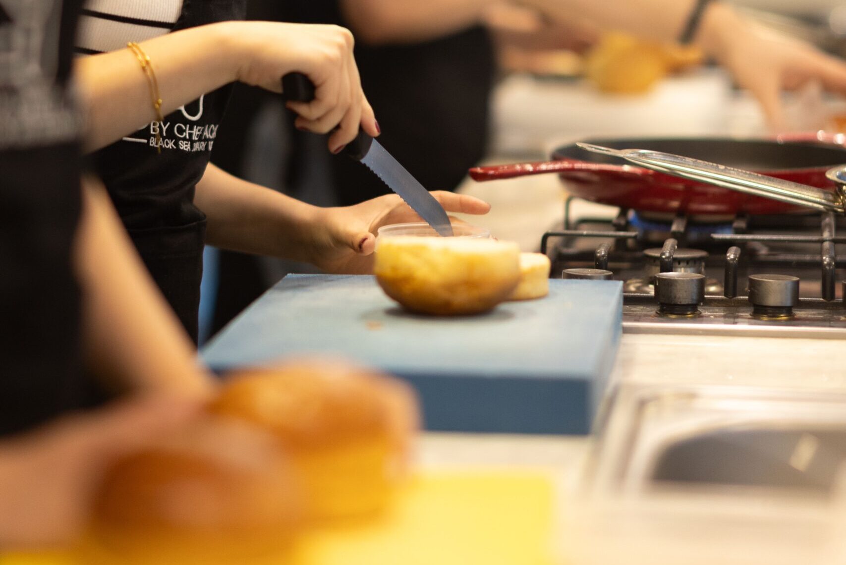 Focused woman slicing bread during a cooking class in Samsun, Türkiye.