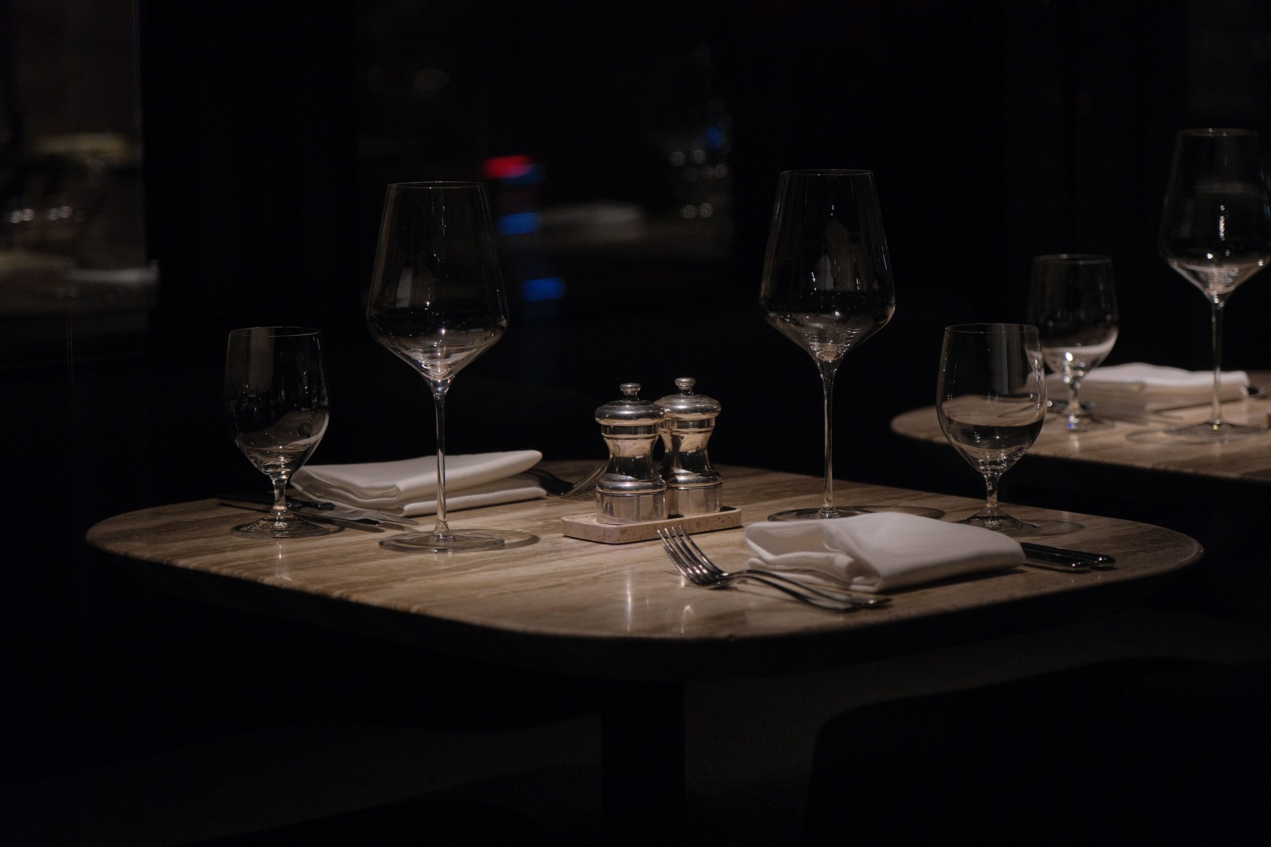 A sophisticated restaurant table setting with wine glasses, napkins, and cutlery, perfect for a romantic evening.